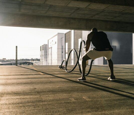 운동과 영양의 시너지 효과: 건강한 삶을 위한 필수 요소 man in black t-shirt and white shorts walking on brown wooden floor