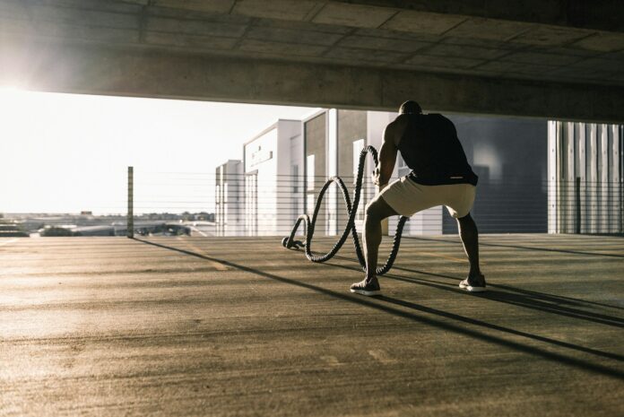 Photo by Karsten Winegeart man in black t-shirt and white shorts walking on brown wooden floor