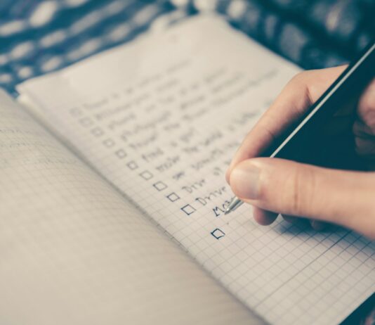 성공을 위한 운동 계획 세우기 person writing bucket list on book