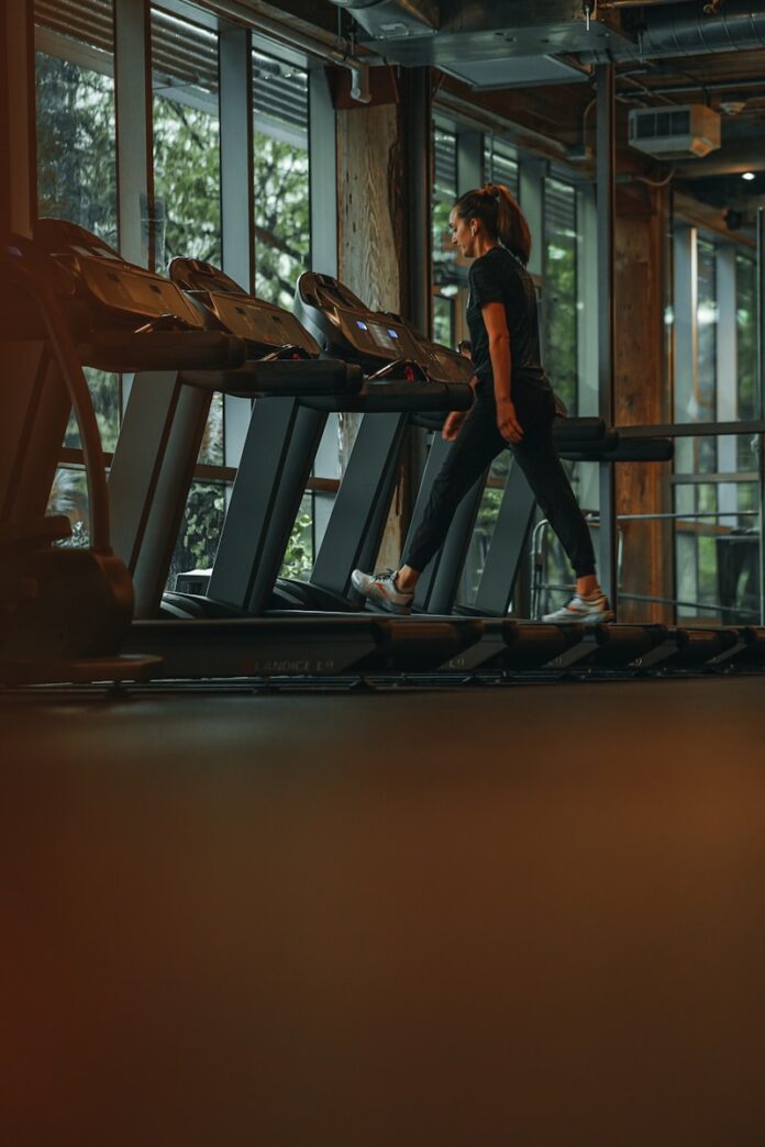 Photo by Mike Cox a woman running on a treadmill in a gym
