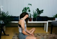 요가로 겨울철 근육 통증 완화하기 woman sitting on area rug near table