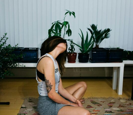 요가로 겨울철 근육 통증 완화하기 woman sitting on area rug near table