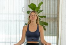 겨울철 허리 통증 완화에 좋은 필라테스 a woman sitting in a yoga position with her eyes closed