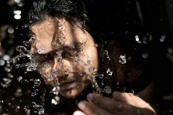Photo by Praveen kumar Mathivanan woman in black shirt with water droplets