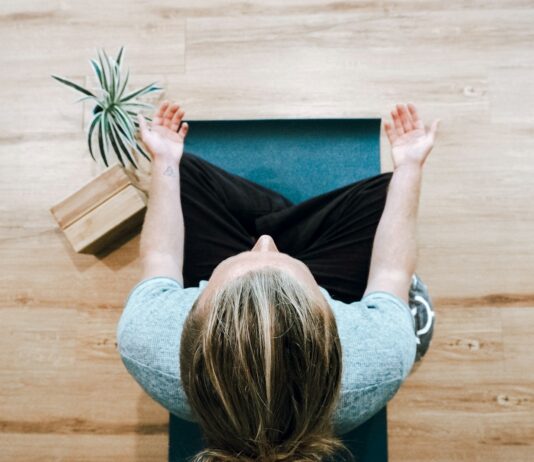 만성 통증 관리와 대체요법 woman in black shirt and gray pants sitting on brown wooden bench